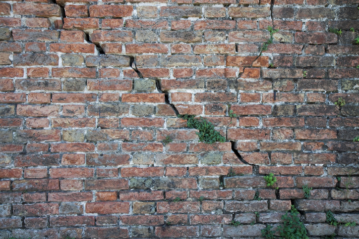 Deep crack in a brick wall